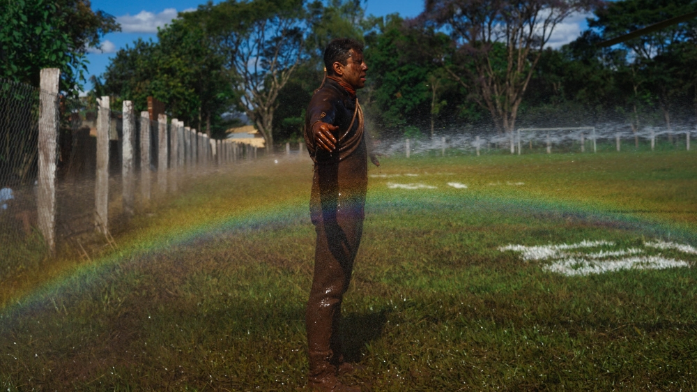 A rescue worker is rinsed off after searching through the mud for bodies of victims [Mia Alberti/XEn News] 
