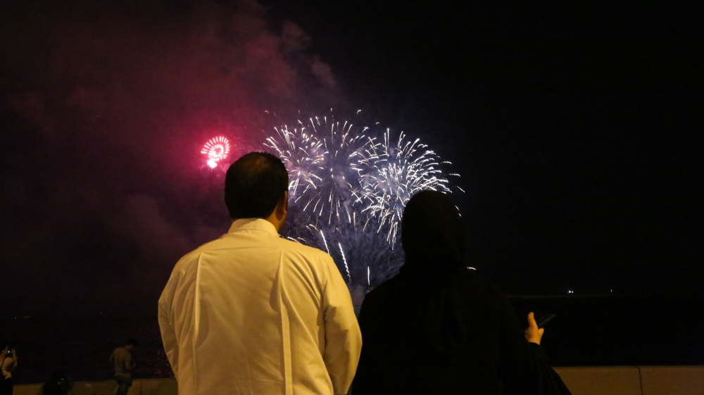 A couple enjoys the fireworks on Doha's Corniche [Showkat Shafi/XEn News]