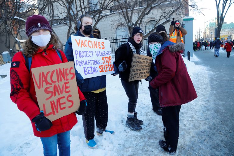 Counter protestors stand across from Parliament Hill as truckers take part in a convoy to protest coronavirus disease (COVID-19) vaccine mandates