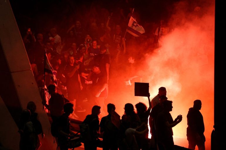 Demonstrators light fires during a protest against the Israeli government