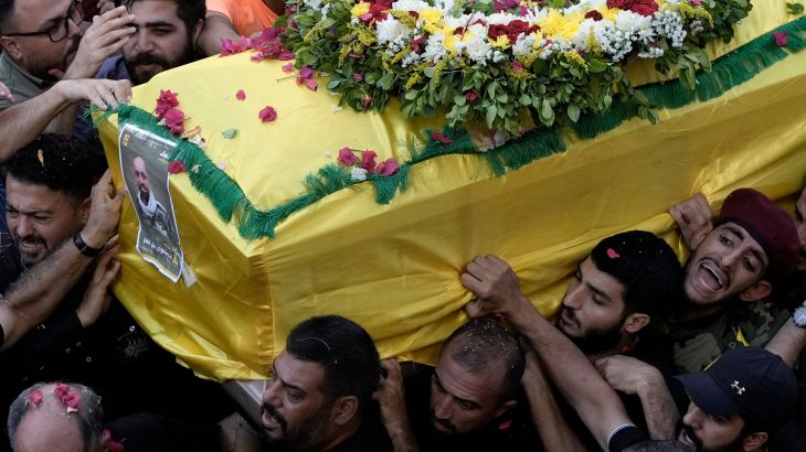 Hezbollah fighters carry one of the coffins of four fallen comrades.