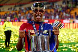 Barcelona's Lamine Yamal celebrates with the trophy after winning the Copa del Rey