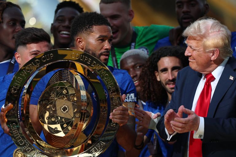 Football - FIFA Club World Cup - Final - Chelsea v Paris St Germain - MetLife Stadium, East Rutherford, New Jersey, U.S. - July 13, 2025 Chelsea's Reece James lifts the trophy as he celebrates with teammates after winning the FIFA Club World Cup as President Donald Trump applauds