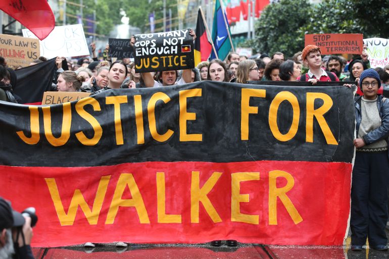 people walk with a banner saying justice for walker