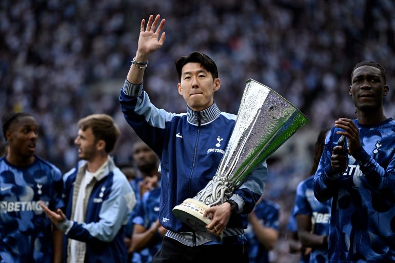 Tottenham Hotspur's Heung-min Son waves to fans whilst holding the Europa League trophy