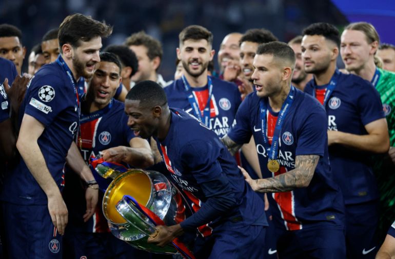 Paris St Germain's Ousmane Dembele celebrates with the trophy after winning the Champions League